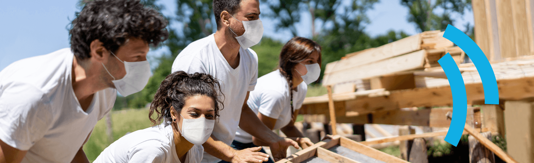 A group of 4 European Solidarity Corps volunteers wearing face masks working together to build something