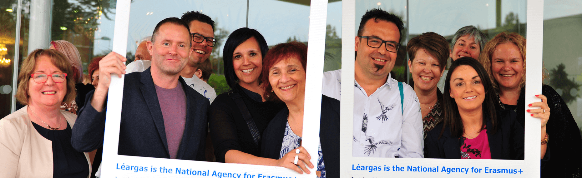 Banner image of a group of Adult learners looking at the camera and smiling holding signs that read 'Léargas is the National agency for Erasmus+'