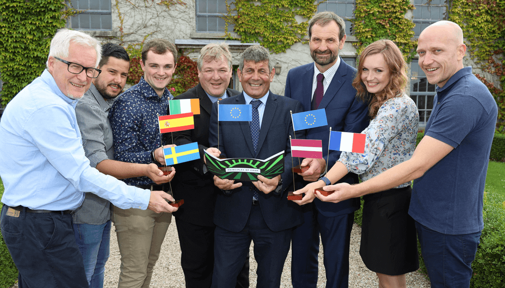 Billy Goodburn, Head of Learning and Development with the Irish Co-operative Organisation Society pictured with project partners holding flags for France, Ireland, Latvia and Spain.