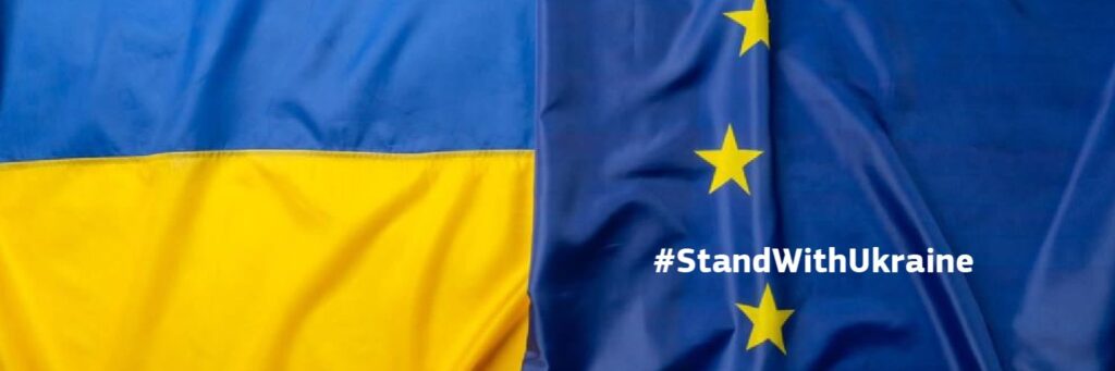 Image shows Ukraine and EU flags with text #StandWithUkraine