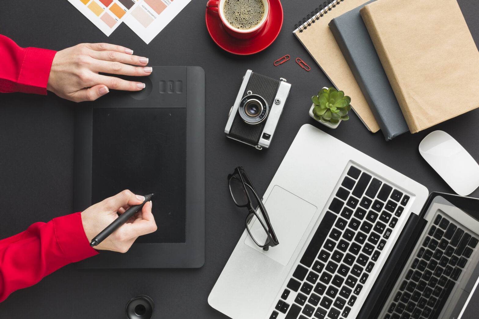 A stock image of a desk with a laptop and design pad in the Centre
